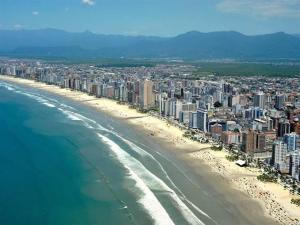 eine Luftansicht auf einen Strand mit Gebäuden und das Meer in der Unterkunft Praia Grande Apartamento Aconchegante pertinho da Praia - 300m in Praia Grande