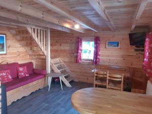 Cabaña de madera con sala de estar con sofá y mesa en La Plagne Chalet cosy calme proche valée, en La Plagne Tarentaise