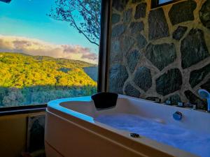 a bath tub in a room with a large window at Rainbow Valley Lodge Costa Rica in Monteverde Costa Rica