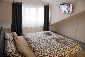 um quarto com uma cama e uma televisão na parede em Central Sweet Home I.M. em Novi Sad