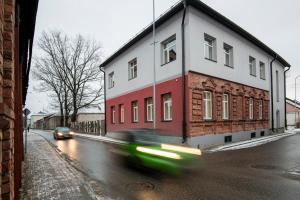 une voiture passant devant un bâtiment dans une rue dans l'établissement RUMI Hotel with Self Check-In, à Jēkabpils