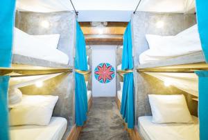 um quarto com 4 beliches e cortinas azuis em Freesoul Hostel em Palomino