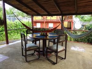 a table and chairs on a patio with a hammock at Posada turística Quenari Wii in Mitú