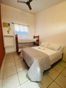 a bedroom with a bed and a ceiling fan at Pousada Berimbau in Arraial d'Ajuda