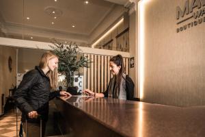 two women sitting at a counter talking at Maytaq Wasin Boutique Hotel in Cusco