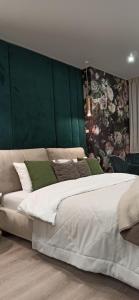 una camera da letto con un grande letto con una parete verde di Citylife Boutique Hotel a Charkiv