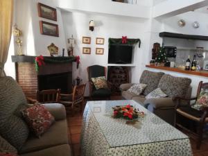 a living room with couches and a table and a fireplace at Casa Rural La Maquinilla in Grazalema