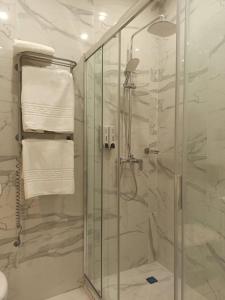 uma casa de banho com um chuveiro e uma cabina de duche em vidro. em Citylife Boutique Hotel em Carcóvia