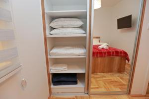 uno specchio in un armadio con asciugamani e un letto di Apartman Una a Pale