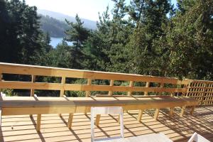 a wooden bench sitting on top of a deck at Cabaña El Mirador de Vichuquén in Vichuquén