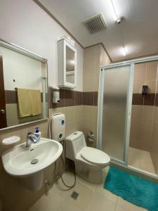 a bathroom with a toilet and a sink and a shower at Deluxe 2 Bedroom Apartment in Mactan