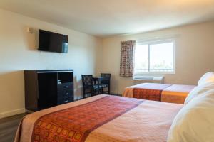 una camera d'albergo con due letti e una televisione di Maywood Inn a Maywood