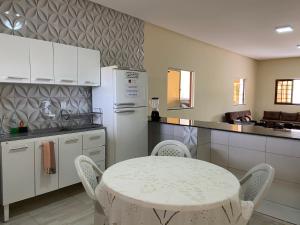 una cucina con un tavolo e un frigorifero bianco di Casa Bem Estar Palestina 03 a Piranhas