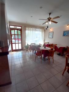 une salle à manger avec des tables et des chaises et un ventilateur de plafond dans l'établissement Hotel Pilmayquen, à Las Grutas
