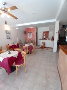 une salle à manger avec des tables et des chaises ainsi qu'une cuisine dans l'établissement Hotel Pilmayquen, à Las Grutas