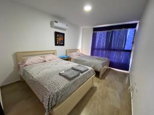 Un dormitorio con dos camas y una ventana en Kattyapartament 1103vista al mar, en Salinas