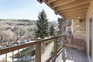 einen Balkon eines Hauses mit einer Bank darauf in der Unterkunft Upper Woodbridge 29C condo in Snowmass Village + 41 Fotos