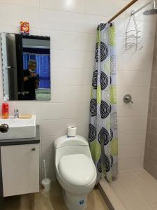 Un baño con inodoro, lavabo y espejo. en Kattyapartament 1103vista al mar, en Salinas 14 fotos más