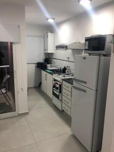 una cocina con estufa y refrigerador en Departamento Piamonte, en Monte Hermoso