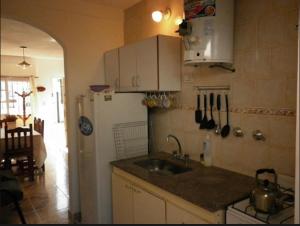 サンタ・テレシータにあるExcelente Duplex a 5 cuadras del mar con WiFi y TV Calle 36 y 6のシンクと白い冷蔵庫のあるキッチン