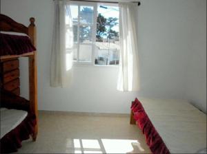 サンタ・テレシータにあるExcelente Duplex a 5 cuadras del mar con WiFi y TV Calle 36 y 6のベッドと窓のある寝室