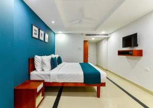 1 dormitorio con 1 cama con pared azul en The Reach Hotel en Kochi