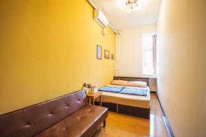 um pequeno quarto com uma cama e um sofá em Train Hostel em Chaozhou