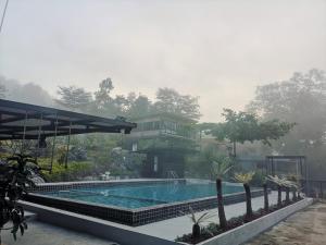 a house with a swimming pool and a resort at Keeree Loft Resort in Thong Pha Phum