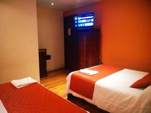 a room with two beds and a window at Hotel Calle Angosta in Cuenca