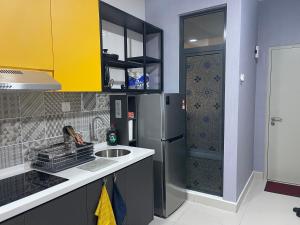 a kitchen with a sink and a refrigerator at Studio Unit@ Ampang Ukay in Ampang
