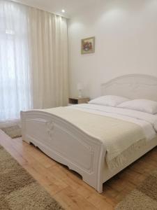 um quarto branco com uma grande cama branca em Lux Apartment in the City Center em Mukacheve