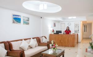 a woman standing at a reception desk in a living room at TJ Guesthouse in Pattaya