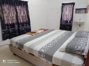 a bedroom with a bed and a sink and two windows at Lubok Jong Riverside, Sedim in Kulim