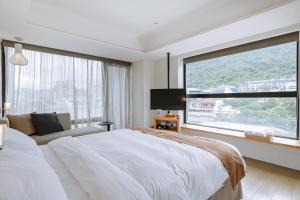 a bedroom with a large bed and a large window at ISPAVITA B&B Resort in Jiaoxi