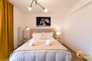 a bedroom with a bed with two towels on it at Quibio Apart Terrace in Braşov