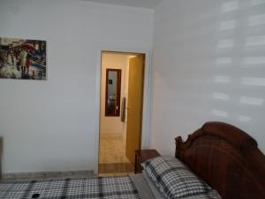 a bedroom with a bed and a door leading to a hallway at Rickaty Lodge Bed and Breakfast, 2 star Hotel, Plane spotting Hotel, Gran Canaria Airport LPA, Gran Canaria, Spain in Las Puntillas