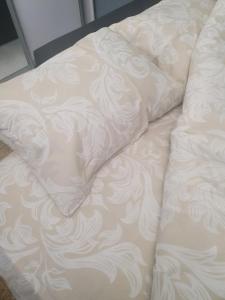 un divano bianco con un cuscino sopra di затишна квартира в центрі a Luc'k