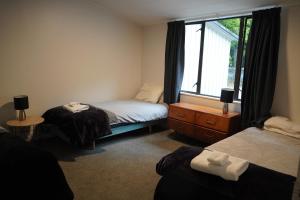 1 dormitorio con 2 camas y ventana en Lazy Daze en Wanaka