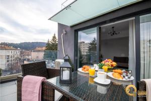 a balcony with a table with food on it at Quibio Apart Terrace in Braşov