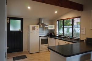 a kitchen with a white refrigerator and a sink at Lazy Daze in Wanaka