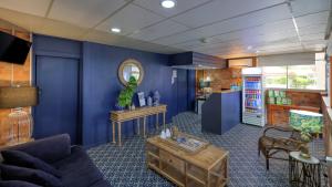 a living room with blue walls and a mirror at Border Motel in Goondiwindi