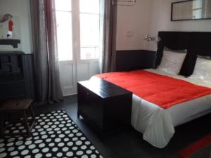 ein Schlafzimmer mit einem großen Bett mit einer roten Decke in der Unterkunft Toki Alai in Saint-Jean-de-Luz
