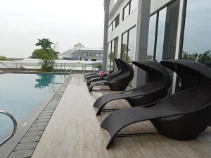 a row of black chairs sitting on the side of a building at One Residence Batam Center Seaview#Altona 10AC# in Batam Center