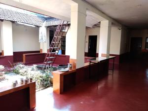 a room with a ladder in the middle of a building at Hanakodu homestay in Sringeri