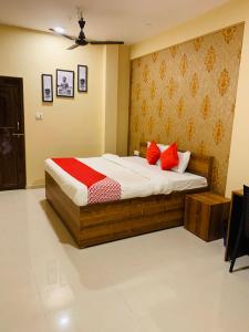 a bedroom with a bed with red pillows on it at Hotel Neelkanth in Jabalpur
