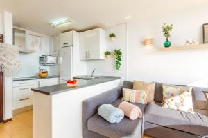 a kitchen and living room with a couch and a counter at Apartment Alcudia Ocean View in Alcudia