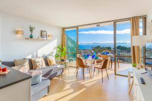 een woonkamer met een bank en een tafel met stoelen bij Apartment Alcudia Ocean View in Alcudia