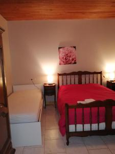 a bedroom with a red bed and two lamps at Massaflo in Besson