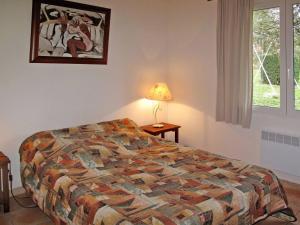 1 dormitorio con cama, lámpara y ventana en Le Logis, charmant gîte provençal en Ampus