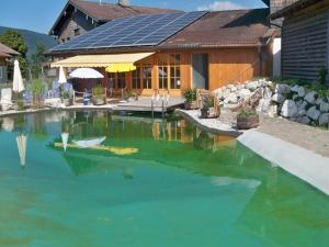a house with a pool of green water in front of it at Andrebauernhof - Biohof - Chiemgau Karte in Inzell